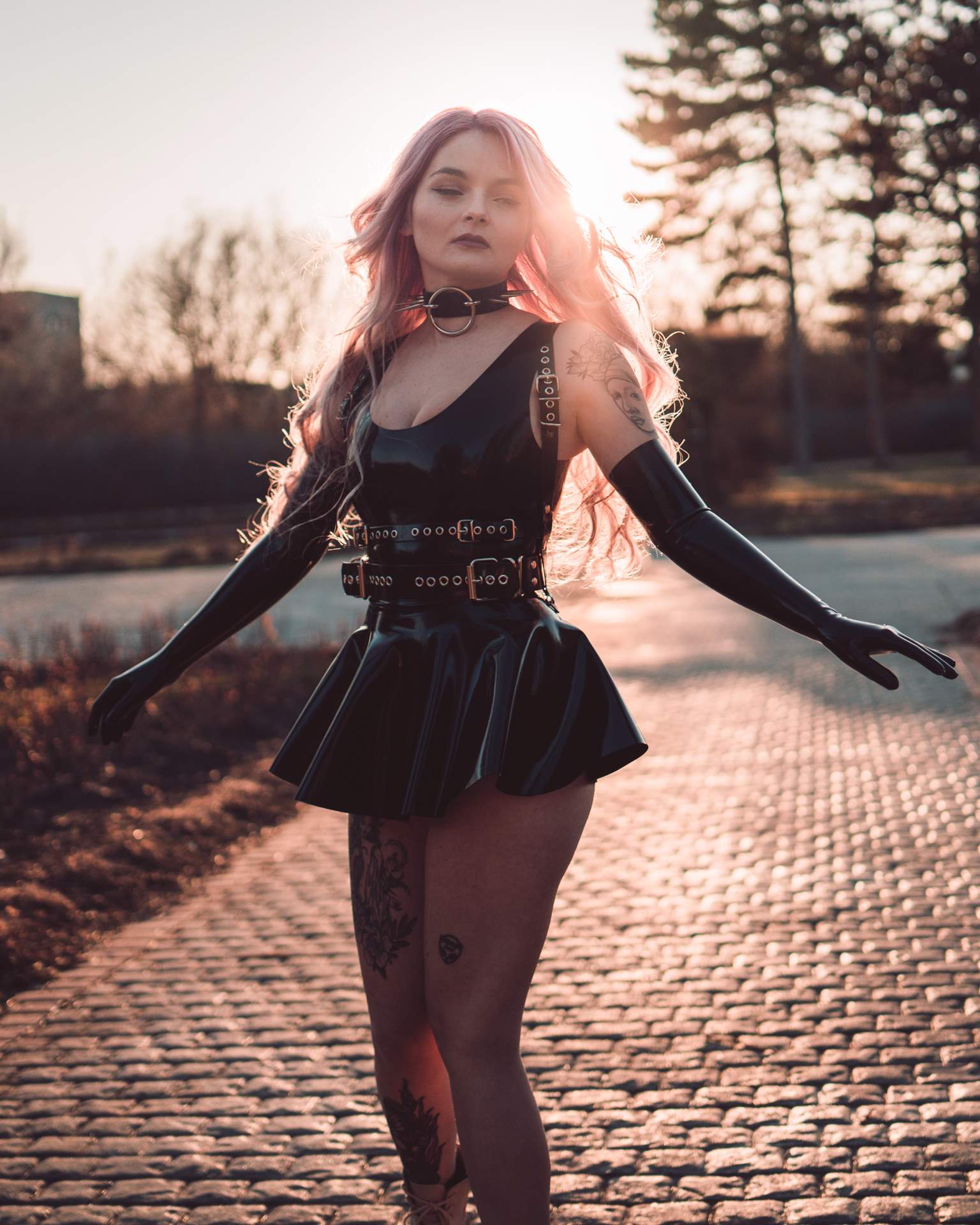 Latex dress accessorized with a striking harness and black choker